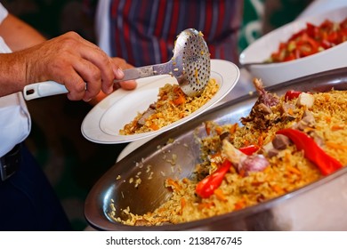 Pilaf is placed in a white plate. Traditional Central Asian festive cuisine. Catering food in traditional national style. Cooking. Nauryz. Selective focus. Shallow depth of field. - Shutterstock ID 2138476745