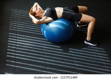 Pilates Adult Woman Pelvic Lift Fitball Exercise Workout At Gym Indoor Swiss Blue Ball. Pilates Woman Pelvic Lift Fitball Exercise Workout At Gym Indoor Swiss Ball