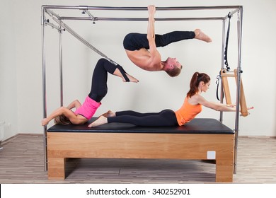 Pilates Aerobic Instructor A Group Of Three People In Cadillac Fitness Exercise.