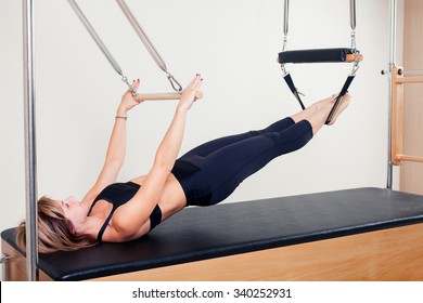 Pilates aerobic instructor woman in cadillac fitness exercise.