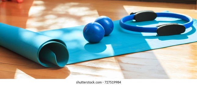 Pilates Equipment. Exercise Mats And Magic Ring On Wooden Floor