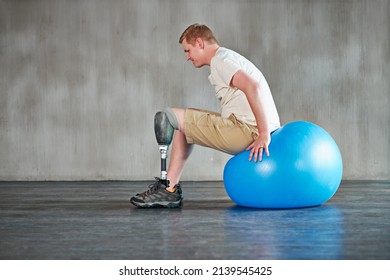 Pilates Is For Everyone. Shot Of A Young Amputee Working Out On A Swiss Ball.