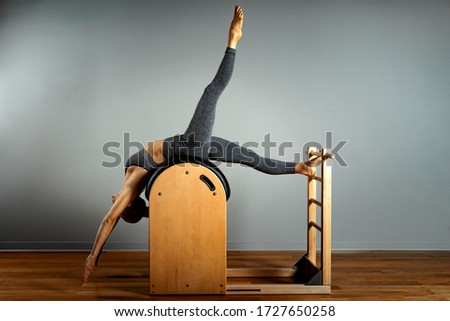 Pilates, fitness, sport, training and people concept - woman doing exercises on a small barrel. Correction of impellent apparatus, correct posture.