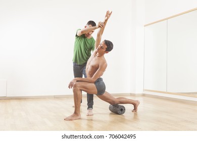 pilates instructor teaching a ballet dancer using foam roller
