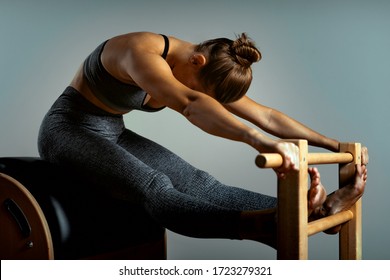 Pilates reformer bed, close-up, woman and instructor doing exercise on reformer simulator for treatment of musculoskeletal system.