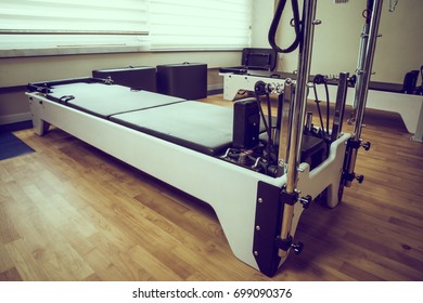 pilates reformer exercise equipment on wooden floor - Powered by Shutterstock