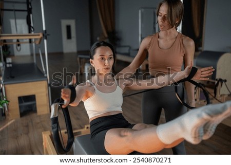 A Pilates session occurs between an instructor and a student in a modern wellness studio
