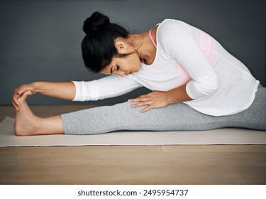 Pilates, stretching and woman in home for exercise, flexibility or holistic training. Yoga, fitness and female yogi warm up for wellness, balance or health for muscle practice on gray wall background - Powered by Shutterstock