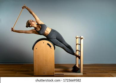 Pilates trainer exercises on a pilates barrel. Body training, perfect body shape and posture correction opporno motor apparatus. Copy space. - Shutterstock ID 1723669582