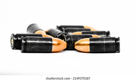 Pile of 9mm pistol bullets on white background, soft and selective focus.