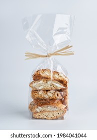 Pile Of Almond Nuts Biscotti Cantucci Biscuits Cookies In Plastic Wrap Packaging For Sale. Italian Dessert Cookies Close Up, Selective Focus, Copy Space. Homemade Bakery Confectionery Concept.