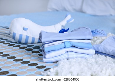 Pile Of Baby Clothes On Bed