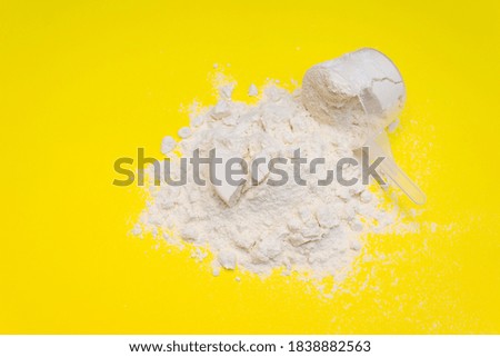 Pile of banana protein powder isolated on yellow background