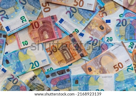 Pile of banknotes on the table in denominations of twenty euros, fifty euros, ten euros, five euros. Background of mixed euro banknotes