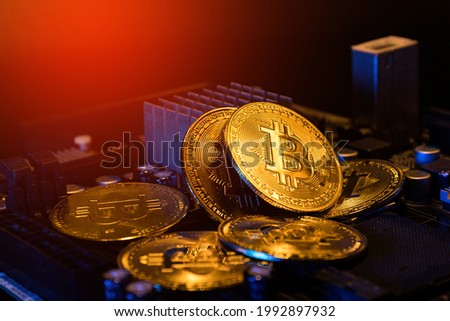 pile of bitcoins on computer mainboard. concept of crypto currency investment.