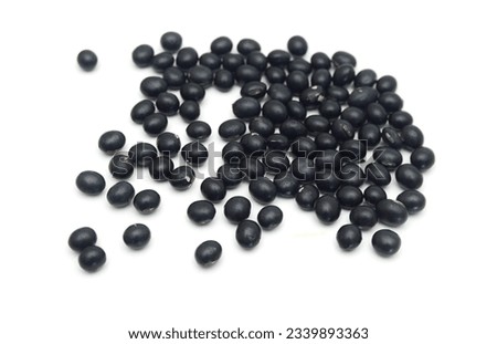 Pile of black beans in wood bowl isolated on white background 