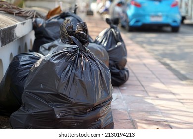Pile of black plastic bags that contains garbage inside on the floor. Waiting for the rubbish keeper officers to take them away. Concept : Waste management. Collected for disposal.                     - Shutterstock ID 2130194213