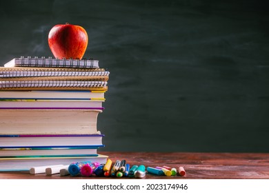 Pile of book and exercise books with shool applies and apple snack with chalkboard.  Back to school concept. - Powered by Shutterstock