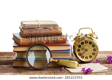 pile of books with clock isolated on white background