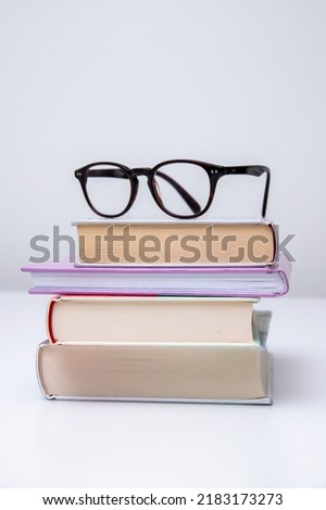 Pile of books with eye glasses on top of them. Good studying concept.