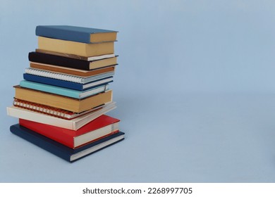 Pile of books on blue background - Shutterstock ID 2268997705