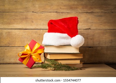 Pile of books, Santa Claus hat, Christmas-tree decorations and Gifts on a wooden background. Holiday concept, christmas, christmas eve - Powered by Shutterstock