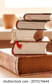 Pile of books, stack of books on the table in the room, library or office. Close up