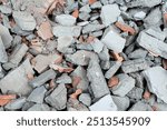 A pile of broken red bricks and fragments of concrete - Pile of debris of a torn dow building. Construction site with large chunks of concrete and stone waste.
