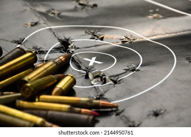 Pile of bullets or ammunitions on black man-target shooting, soft and selective focus on center point (x) of man-target shooting paper.