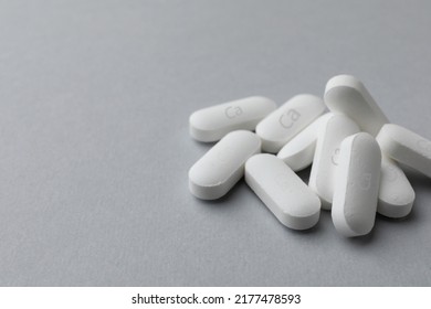 Pile Of Calcium Supplement Pills On Light Grey Background, Closeup. Space For Text