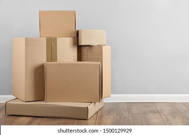 Pile of cardboard boxes near light blue wall indoors. Space for text