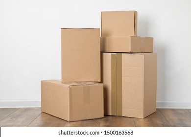 Pile Of Cardboard Boxes Near White Wall Indoors