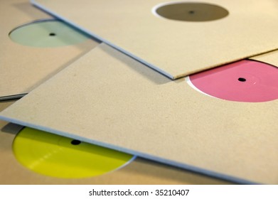 Pile Of Cardboard Sleeve Vinyl Music Records With Colorful Blank Labels.