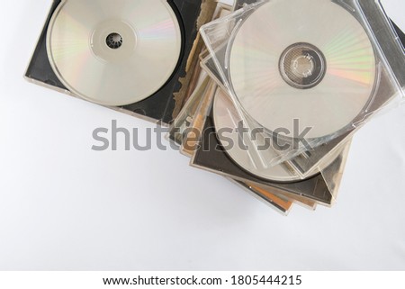 A pile of CDs and DVDs. The surface of the discs and cover.