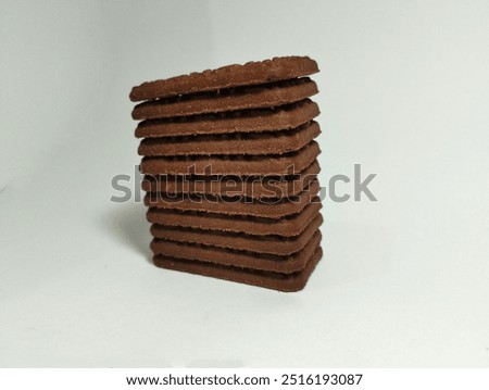 a pile of chocolate biscuits in the shape of a rectangular tower on the top of white background studio shot