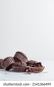 Pile of chocolate muffins on a white background - Shutterstock ID 2141366499