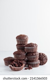 Pile of chocolate muffins on a white background - Shutterstock ID 2141366503