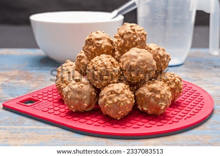 A pile of chocolate nut clusters resting on a red silicone baking pad