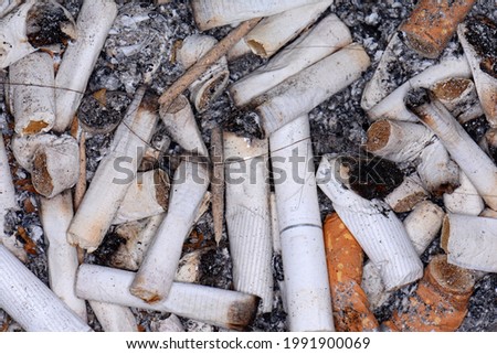 A pile of cigarette butts end stubs, butts, ash background