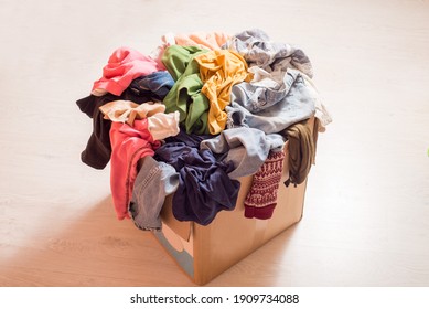Pile of clothes in a large cardboard box. Sorting wardrobe and decluttering