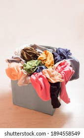 Pile of clothes in a large gray box. Recycling textiles