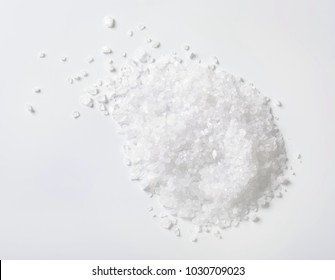 pile of coarse grained sea salt on white background