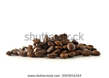 Pile of coffee beans in the center of a white table. Front view. Horizontal composition.