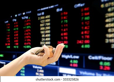 pile of coins in hand on blur perspective stock market number background