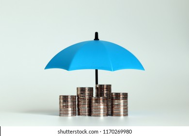 A pile of coins with an open blue umbrella.