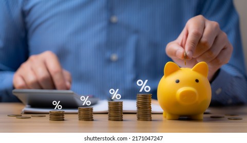 pile of coins and piggy bank, Interest rate and dividend concept Businessman is calculating income and return on investment in percentage. income, return, retirement, compensation fund, investment