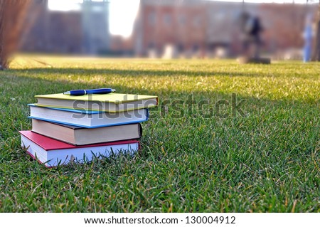a pile of colorful books on lawn in campus