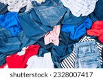 Pile of colorful clothes. Abstract background of used clothes for donation, online selling, recycling. Fast fashion, household, home wardrobe cleaning, uncluttering. Top view