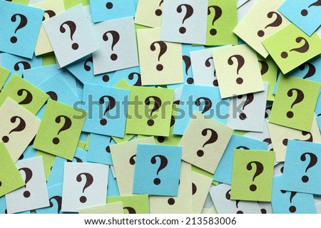 Pile of colorful paper notes with question marks. Closeup.