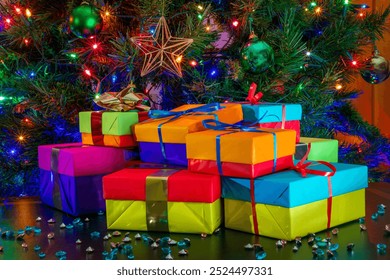 Pile of Colorful Wrapped Gifts Beneath Christmas Tree with Ornaments and Sparkling String Lights - Powered by Shutterstock